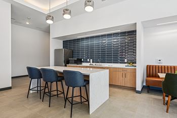 A kitchen with a bar area and chairs.